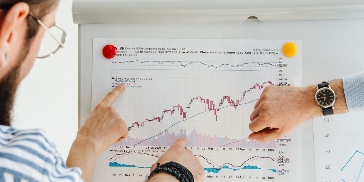 A group of business professionals discussing a financial growth chart, representing the significant investment flowing into quantum computing.