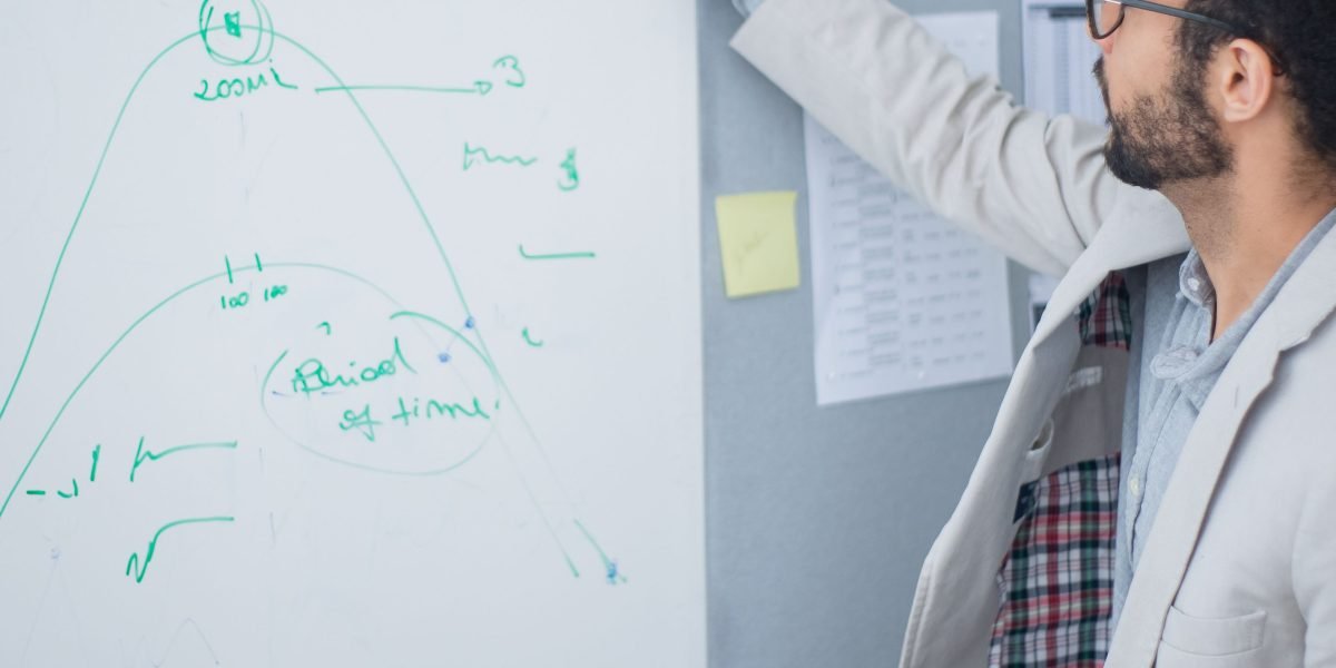A team actively discussing and mapping out a strategy on a whiteboard, reflecting the process of making critical tech infrastructure decisions.