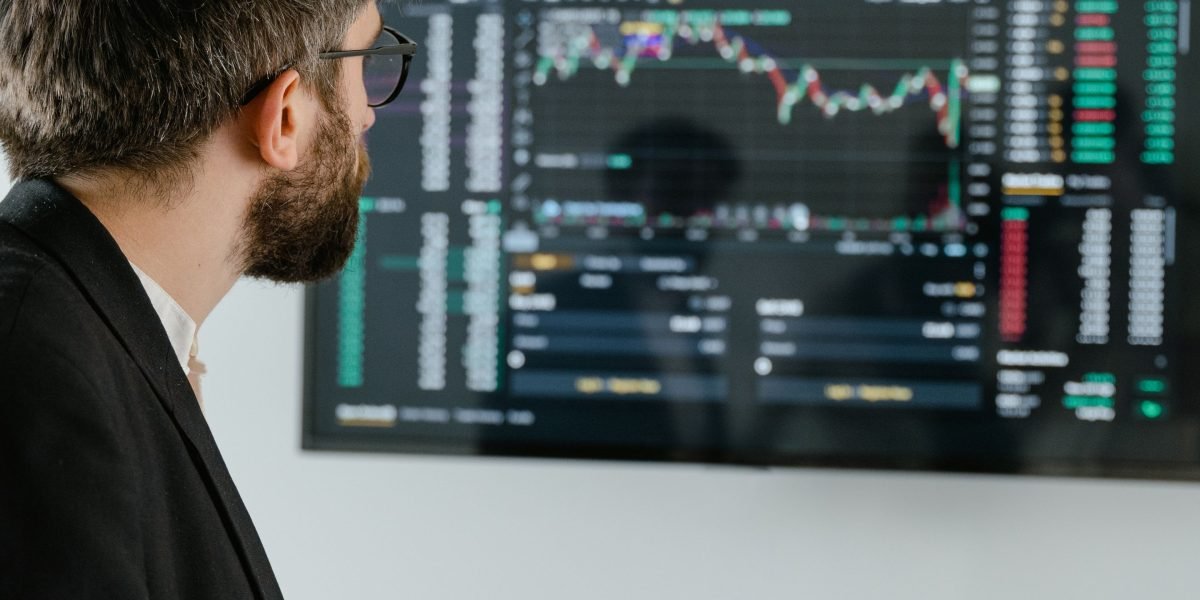 A focused individual in a modern workspace, analyzing data on multiple screens, symbolizing the effort to identify emerging trends and future players.