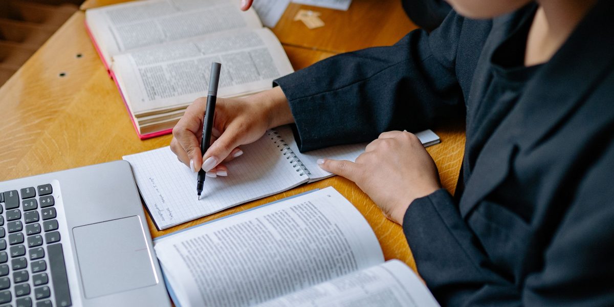Someone actively reading a textbook, taking notes and engaging with the material.