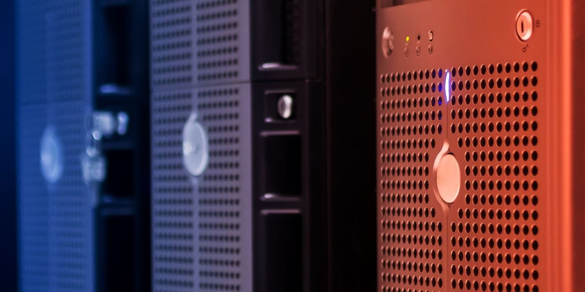 A professional meticulously working with server racks or technical equipment, representing the hands-on nature of IT roles.