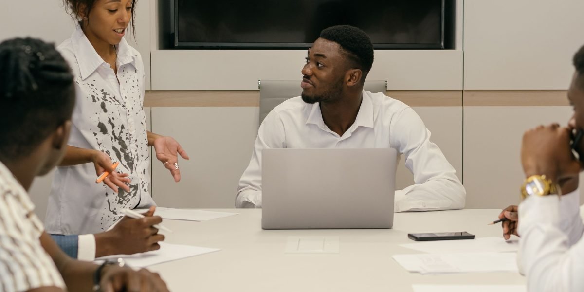 Business leaders in a modern office setting, deep in discussion, planning strategic technology and talent initiatives.