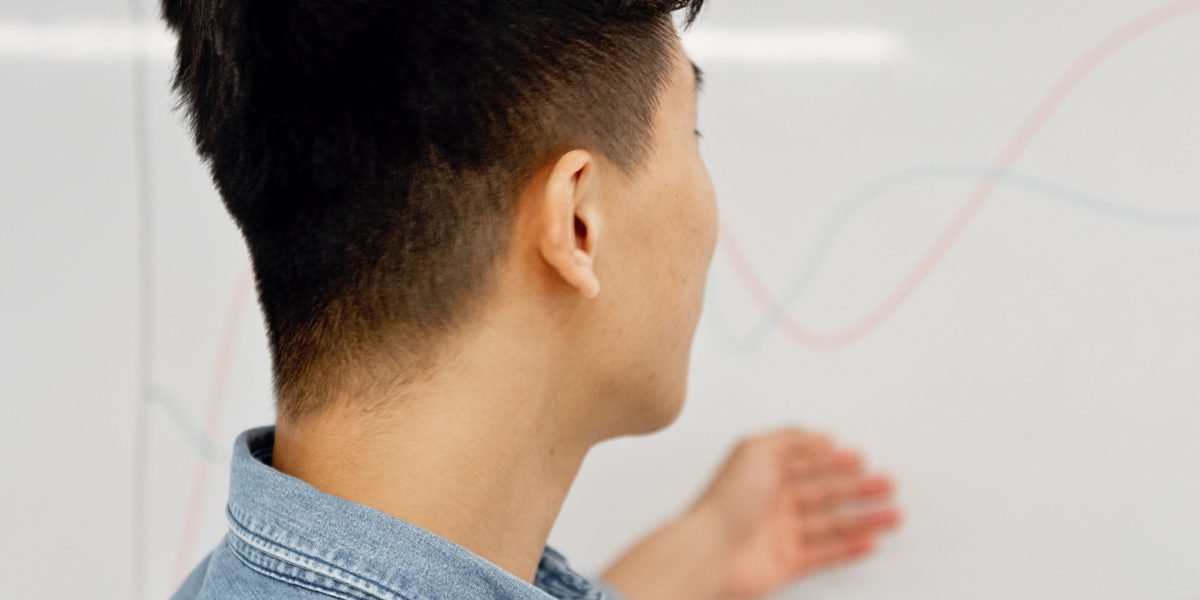 A person intently analyzing complex information, symbolizing the challenge of discerning valuable trends from noise.
