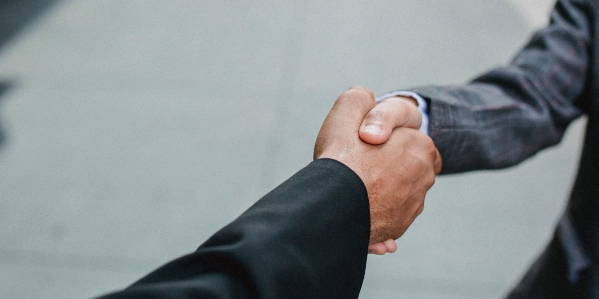 Two professionals shaking hands, symbolizing a successful negotiation or partnership.