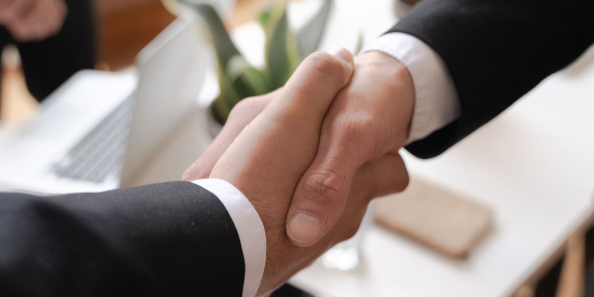 Two professionals shaking hands, symbolizing the formation of new partnerships with technology providers.