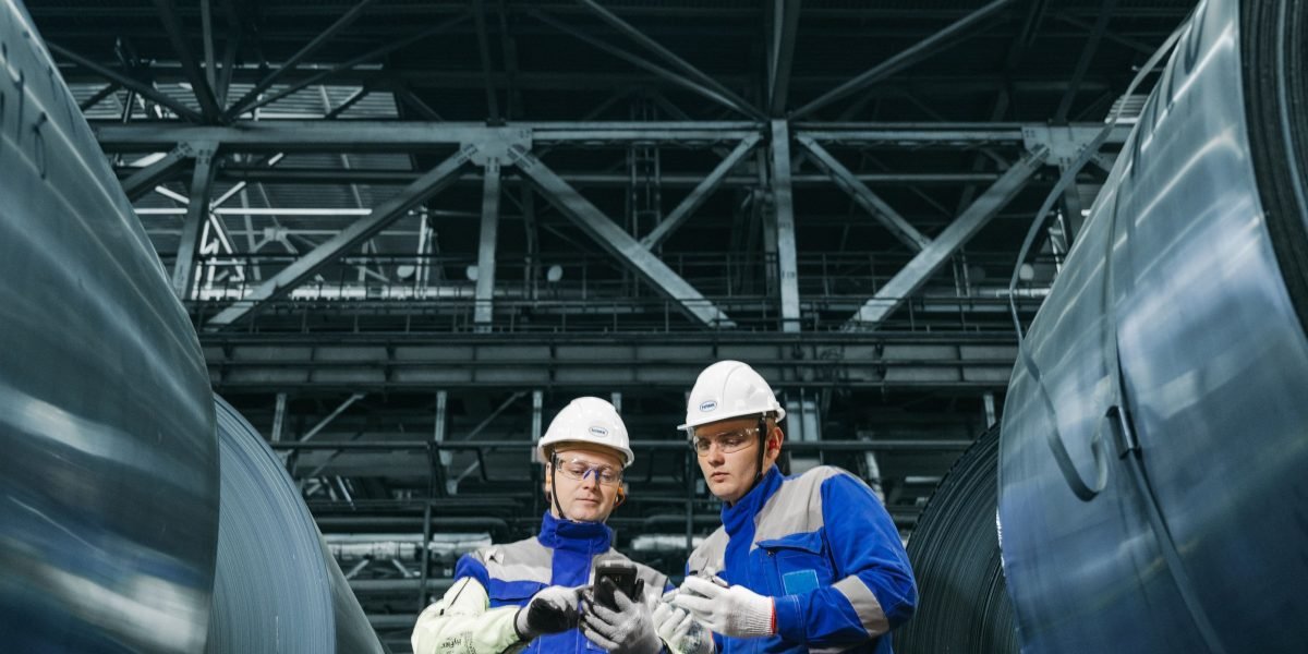 A team of workers on a factory floor conducting a quality inspection, representing practical application in industry.