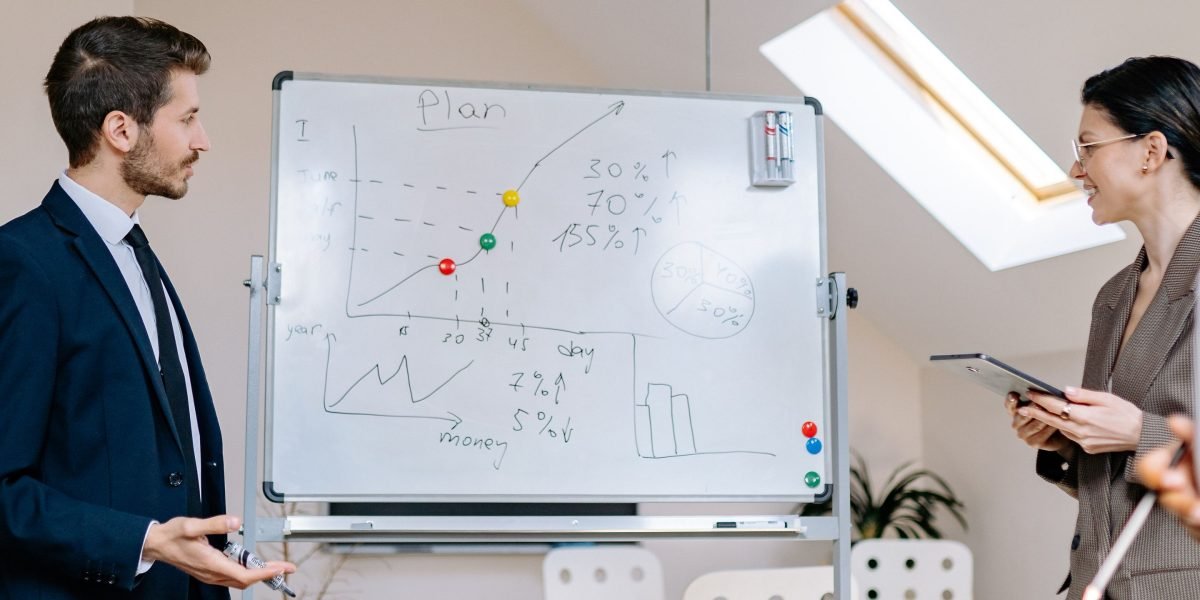 A business leader outlining strategic plans on a whiteboard, translating tech trends into actionable business goals.