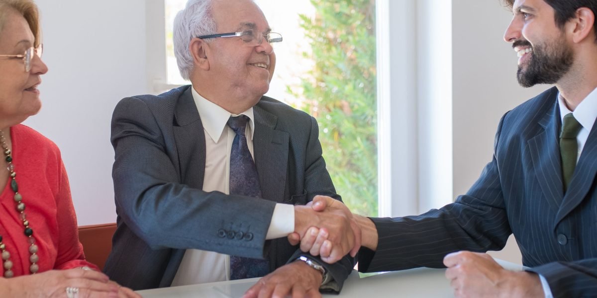 Two business partners shaking hands, signifying a successful agreement or investment in the Albany tech sector.