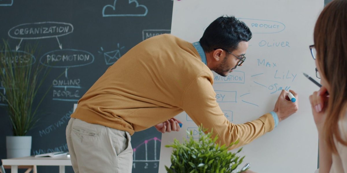 A presenter engaging an audience with a visual display, reflecting the communication of new ideas and expertise.